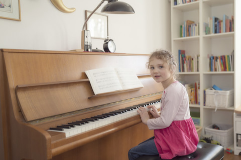 Kleines Mädchen spielt zu Hause Klavier, lizenzfreies Stockfoto