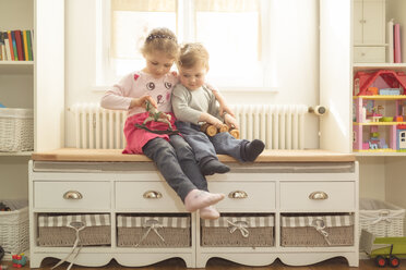 Bruder und Schwester mit Holzspielzeug zu Hause - OPF000050