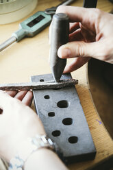 Goldsmith preparing with mandrel wedding ring work piece - KRPF001330
