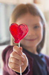 Girl holding heart-shaped lollipop - SARF001477