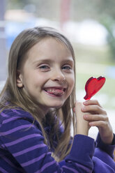 Girl holding heart-shaped lollipop - SARF001431