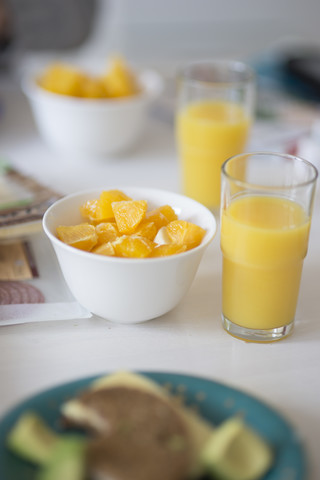 Schale mit Orangenscheiben und Glas Orangensaft, lizenzfreies Stockfoto