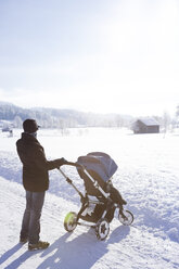 Austria, Salzburg State, Steinernes Meer, mother with baby carriage in winter - DISF001404