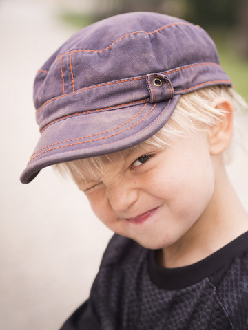 Blond boy pulling funny faces stock photo