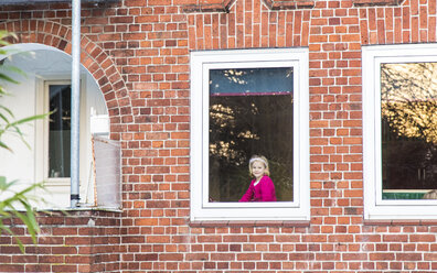 Deutschland, Kiel, Kleines Mädchen schaut aus dem Fenster - JFEF000561
