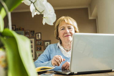 Porträt einer älteren Frau zu Hause mit Laptop - UUF003487