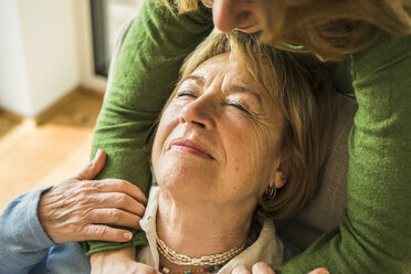 Adult granddaughter hugging grandmother - UUF003490