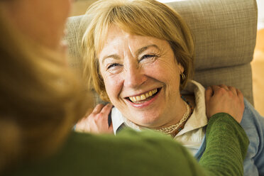 Smiling grandmother looking at adult granddaughter - UUF003491