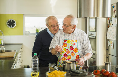 Zwei ältere Freunde kochen in der Küche - UUF003501