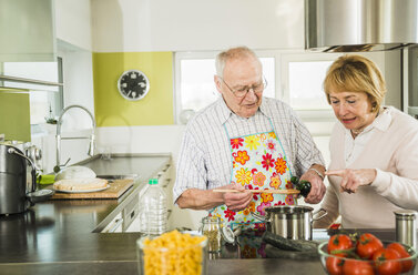Senior couple cooking in kitchen - UUF003509