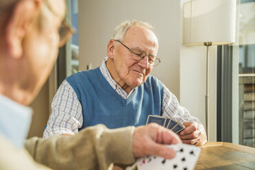 Zwei ältere Freunde spielen Karten - UUF003520