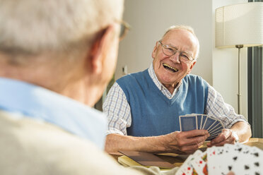 Zwei ältere Freunde spielen Karten - UUF003521