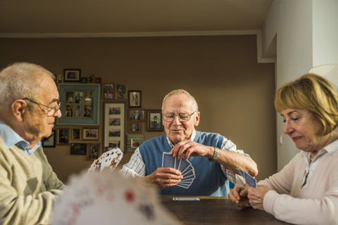 Ältere Freunde spielen Karten, lizenzfreies Stockfoto