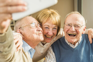 Fröhliche Senioren machen ein Selfie - UUF003530