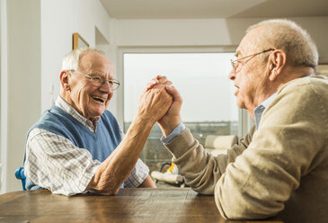 Two senior friends arm wrestling - UUF003545