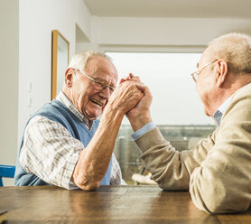 Zwei ältere Freunde beim Armdrücken - UUF003546