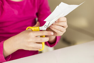 Girl cutting piece of paper - JFEF000581
