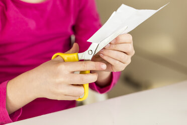 Mädchen schneidet ein Stück Papier - JFEF000581