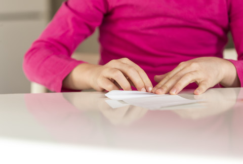 Girl folding piece of paper stock photo