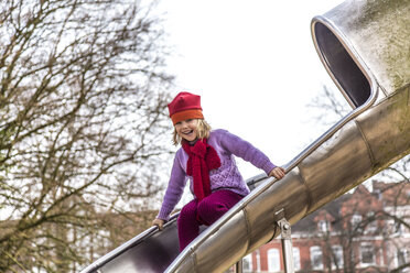 Germany, Kiel, Little girl with red cap playing on shoot - JFEF000591