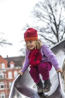 Deutschland, Kiel, Kleines Mädchen mit roter Mütze spielt auf Schießstand - JFEF000592