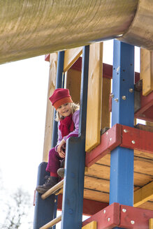 Deutschland, Kiel, Kleines Mädchen mit roter Mütze spielt auf Spielplatz - JFEF000597