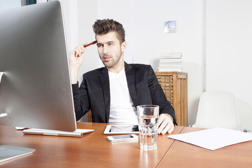 Young man working at desk in an office - PATF000042