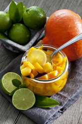 Preserving jar of pickled pumpkin, Hokkaido pumpkin and bowl of limes - CSF024682