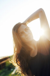 Woman with hand behind her head at backlight - BZF000046