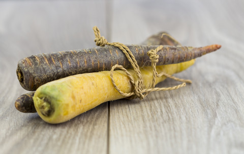 Gelbe und violette Möhren, Bio-Gemüse auf Holz, lizenzfreies Stockfoto