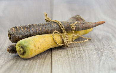 Yellow and prple carrots, organic vegetables on wood - JUNF000226