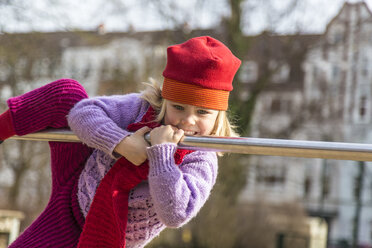 Deutschland, Kiel, Kleines Mädchen mit roter Mütze spielt am Tresen - JFEF000598