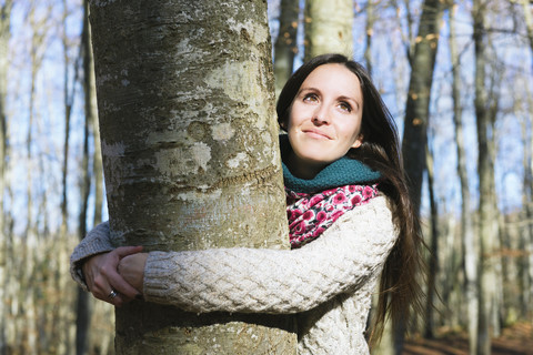 Porträt einer Frau, die eine Buche umarmt, lizenzfreies Stockfoto