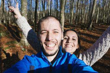 Porträt eines glücklichen Paares, das ein Selfie in einem Wald macht - GEMF000072