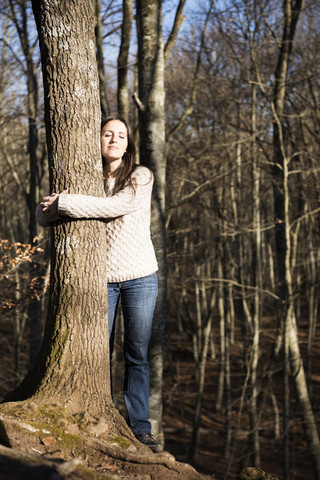 Woman hugging a beech tree in the forest stock photo