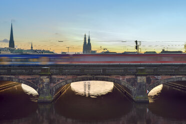 Germany, Hamburg, train on Lombard bridge on the Inner Alster Lake at sunset - RJF000405