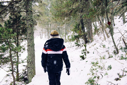 Junge geht im Winter durch den Wald - GEMF000076
