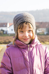 Portrait of little girl wearing woolly hat and pink winter jacket - LVF002944