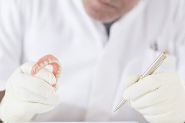 Dental technician examining dentures - DRF001515