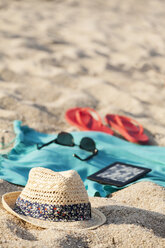 Handtuch, Sonnenbrille, Flip-Flops, Strohhut und digitales Tablet am Sandstrand - BZF000062