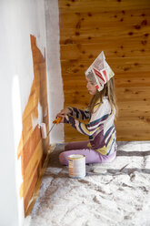 Mädchen malt Holzwand mit Farbrolle - SARF001438