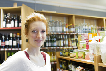 Porträt einer lächelnden jungen Frau in einem Naturkostladen - SGF001389