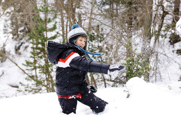 Glücklicher Junge spielt mit Schnee im Wald - GEMF000086