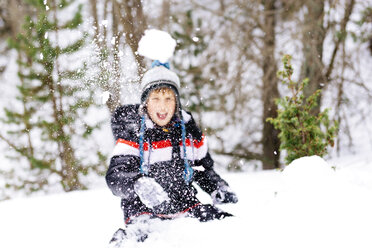 Happy boy throwing a snowball in the woods - GEMF000088