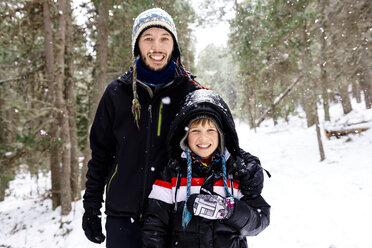 Glücklicher Mann und Junge im Wald bei Schneefall - GEMF000082