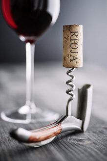 Glas Rotwein, Korkenzieher und Weinkorken mit der Aufschrift 