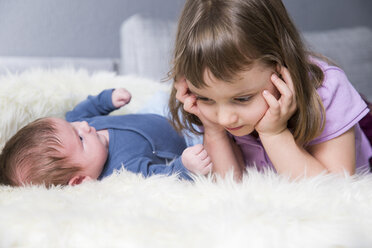 Little girl and newborn brother together on sheepskin - ROMF000055