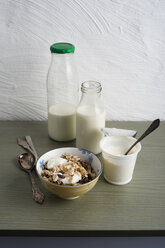 Schale mit Müsli, Flaschen mit Milch und Becher mit Naturjoghurt - MYF000912