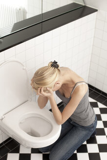 Verzweifelte magersüchtige junge Frau auf der Toilette - DRF001537