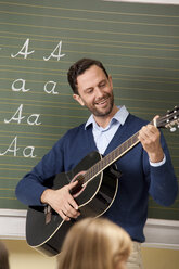 Lehrerin spielt Gitarre im Klassenzimmer - MFRF000086